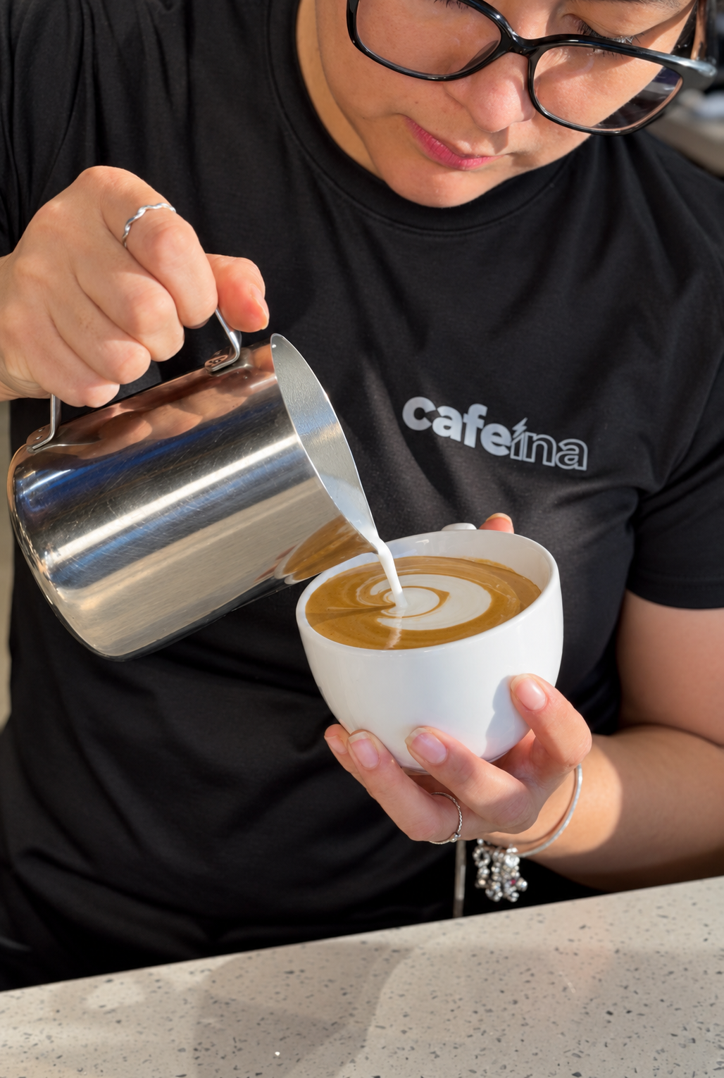 Barista de Cafeína preparando arte latte